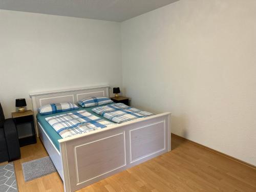 a small bedroom with a bed with blue pillows at Ferienwohnung Kraus 2-4 Pers in Herbolzheim