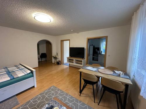 a living room with a table and a bed at Ferienwohnung Kraus 2-4 Pers in Herbolzheim