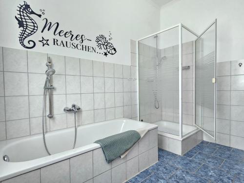a bathroom with a bath tub and a fish decal at Ferienhof Dahl in Wurster Nordseeküste