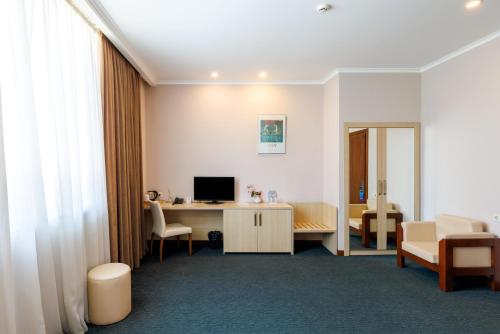 a room with a desk with a computer and a chair at Cruise Hotel in Tbilisi City