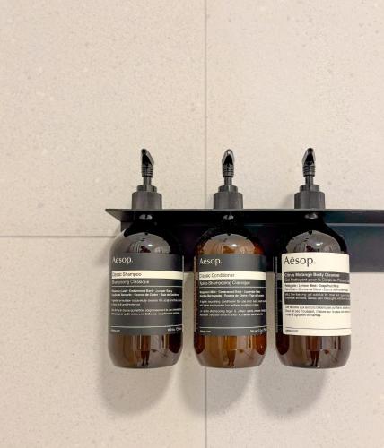 three bottles of soap hanging on a wall at LOEWENHERZ HOMES Mittenwald - Bijou in Mittenwald
