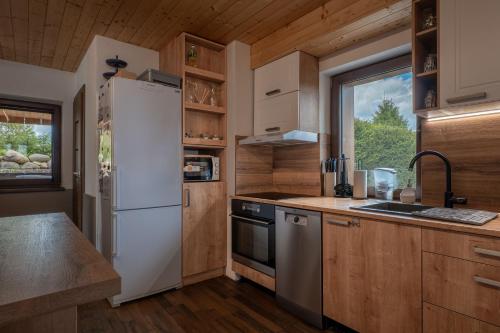 a kitchen with a white refrigerator and a sink at Chalet Dereše in Liptovský Mikuláš