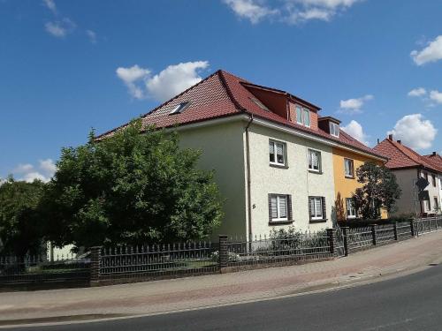 a green and white house on the side of a street at Ferienwohnung Grapatin in Teterow