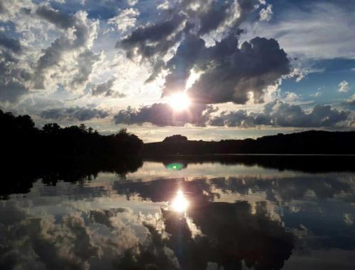 a reflection of the sun on a lake at Ferienhaus Altes Kabinett in Schorssow
