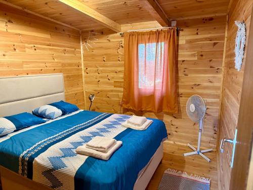 a bedroom with a bed in a wooden cabin at Ada Gioia in Ulcinj