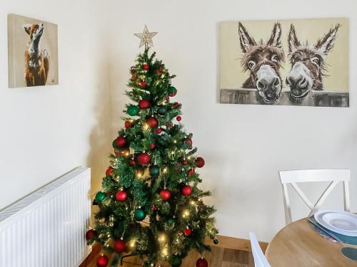 a christmas tree in a living room with two horses at Cothi Cottage - Uk49588 in Llansawel