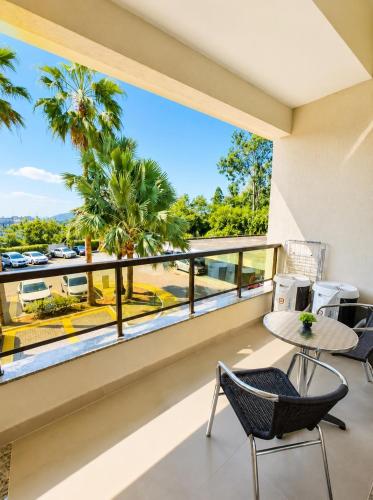 a balcony with a view of a parking lot and palm trees at Apartamento Vista Jardim in São Domingos