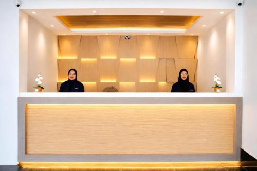 two women are standing behind a reception desk at Paradise Resort Langkawi in Pantai Cenang