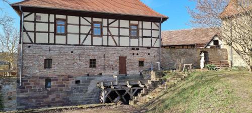 a large building with a bridge in front of it at Pension Stadtmühle Allstedt in Allstedt
