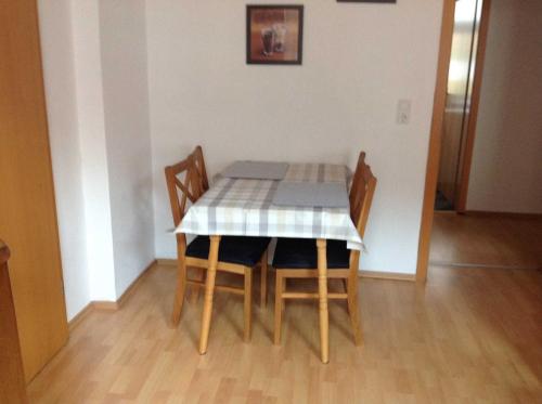 a dining room table and chairs with a checkered table cloth at Ferienwohnung Gleißner Hartmann in Sangerhausen
