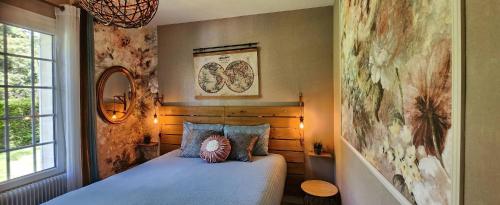 a bedroom with a bed with a blue comforter at Mont Joly Gîte in Soumont-Saint-Quentin
