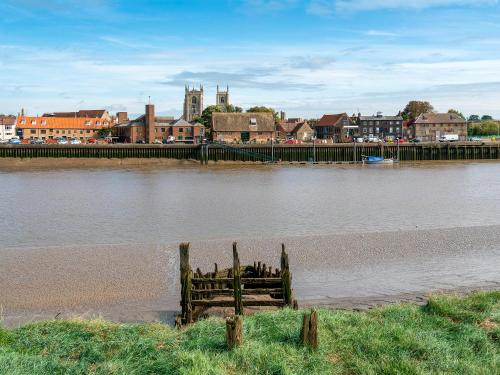 a body of water with a town in the background at Shepherds Hut - Uk49729 in King's Lynn