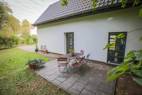 a patio with a table and chairs in front of a house at Kölp - Wald und Mee h r in Kölpinsee