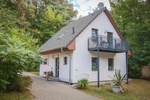 a white house with a balcony on top of it at Kölp - Wald und Mee h r in Kölpinsee