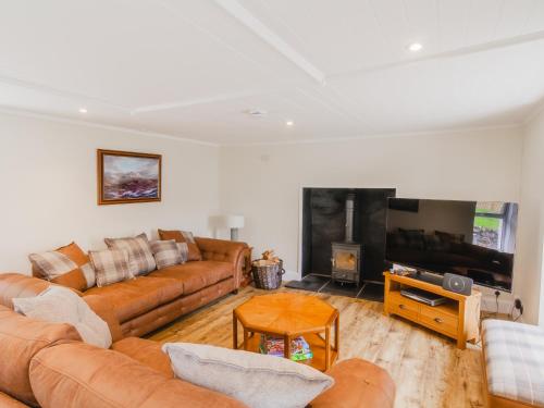 a living room with a couch and a television at Dalnaglar Cottage - Uk30260 in Cray