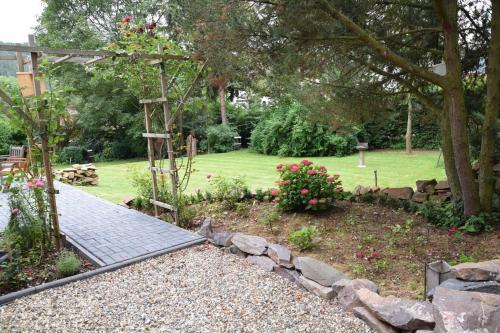 a garden with a stone walkway and flowers at Ferienhaus SonnenFänger in Hemfurth-Edersee