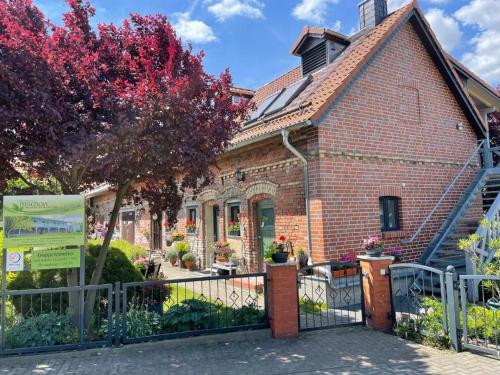 a brick house with a fence in front of it at Pension Mochow in Schwielochsee