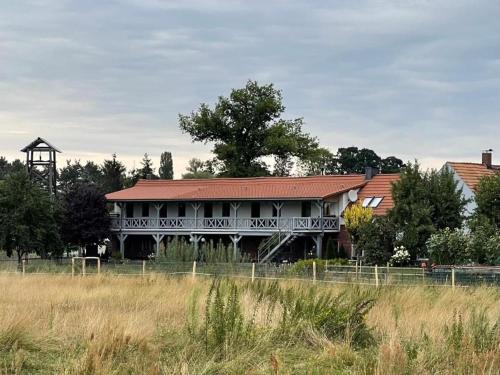 a large building with a sign on it in a field at Pension Mochow in Schwielochsee
