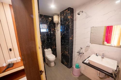 a bathroom with a white toilet and a sink at Hotel Sonajhuri in New Digha