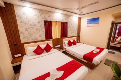 two beds in a hotel room with red pillows at Hotel Sonajhuri in New Digha