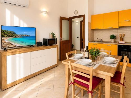 a kitchen and dining room with a table and a tv at Luna House - Key to Villas in Valledoria