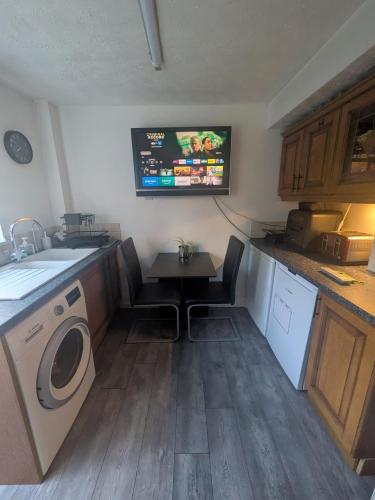 a kitchen with a washing machine and a tv on the wall at Bramcote House in Bramcote