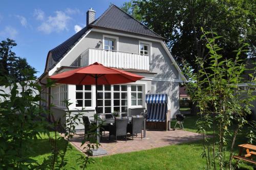 a house with a table and chairs and an umbrella at Haus "Fock" in Prerow