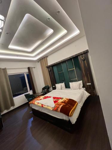 a bedroom with a large bed with a green headboard at gulmarg peak view resort in Gulmarg