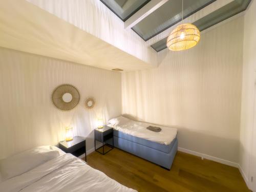 a bedroom with two beds and a light fixture at luxe stadsappartement Workum in Workum