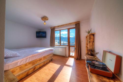 a bedroom with a bed and a large window at Rhodope House Momchil Yunak in Momchilovtsi