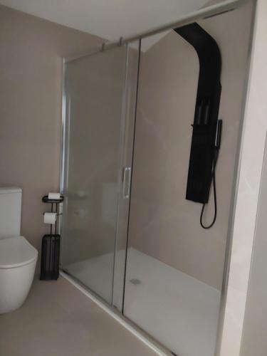 a shower in a bathroom with a phone on the wall at La maison d'Amatxi in Itxassou