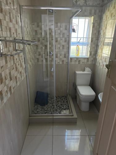 a bathroom with a shower and a toilet at Royaltics Lumina house in Weltevredenpark