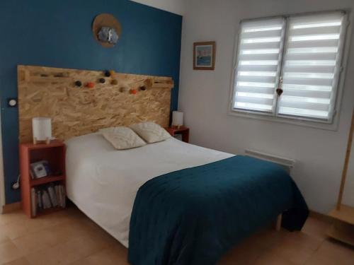 a bedroom with a white bed and a blue wall at La maison d'Amatxi in Itxassou