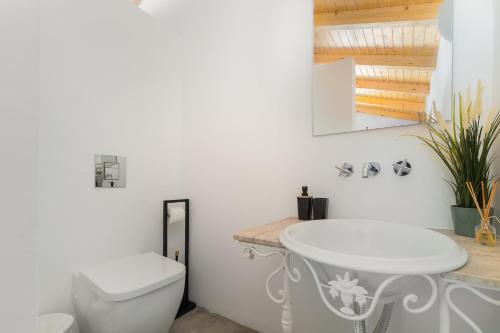 a bathroom with a white sink and a toilet at Quinta de Loubite by Sweethomes in Lagoa