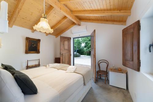 a bedroom with a large white bed and a wooden ceiling at Quinta de Loubite by Sweethomes in Lagoa
