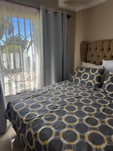 a bedroom with a bed and a large window at Royaltics Lumina house in Weltevredenpark
