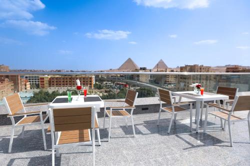 a patio with two tables and chairs on a roof at Occidental Cairo Grand Museum in Cairo