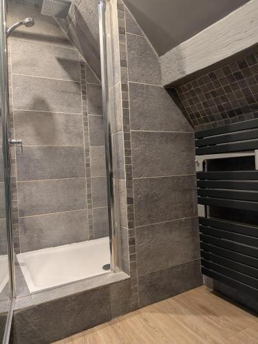 a shower with a glass door in a bathroom at Au Bois Dormant B&B in Tillé