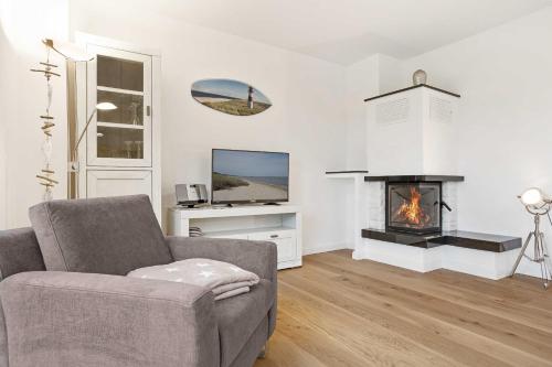a living room with a couch and a fireplace at Fennenblick in List
