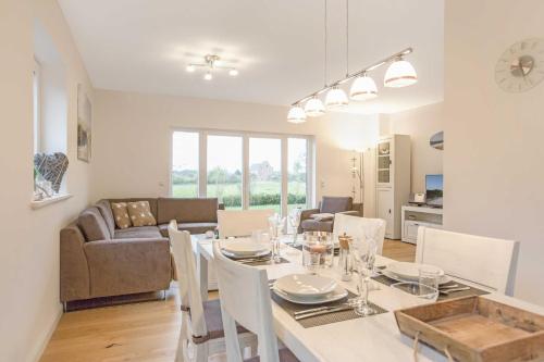 a dining room and living room with a table and chairs at Fennenblick in List