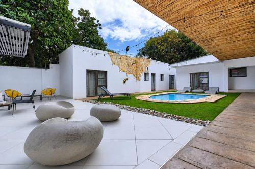 a courtyard with a swimming pool and a house at Hunni Hotel Melrose Edge in Johannesburg