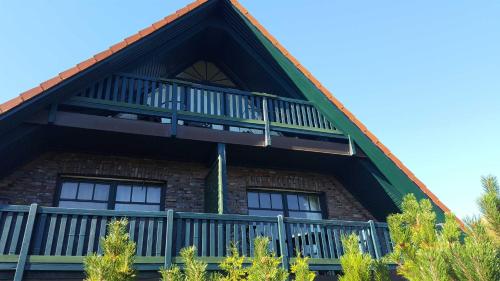 a building with a balcony on the side of it at Urlaubslust Ferienhaus 12 in Trassenheide