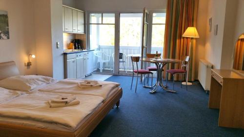 a hotel room with a bed and a kitchen and a table at "Residenz Seeblick" Studio 23 mit seitlichem Ostseeblick in Ostseebad Sellin