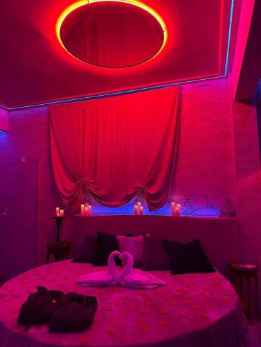 a bedroom with red lighting and a bed with a pink bedspread at Tecaia Secret Luxury Suite in Formia