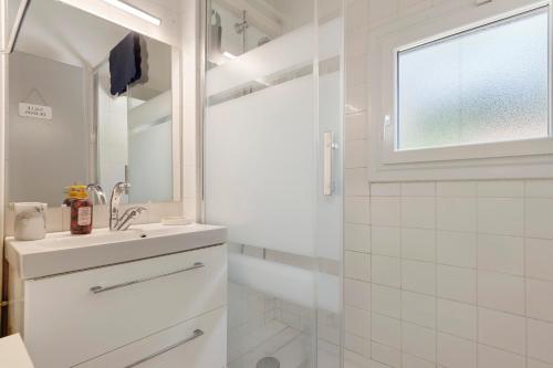 a white bathroom with a sink and a shower at Villa ctl - carcans, médoc in Maubuisson