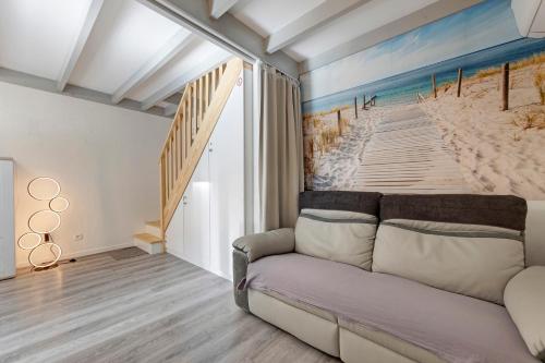 a living room with a couch and a painting of a beach at Villa ctl - carcans, médoc in Maubuisson