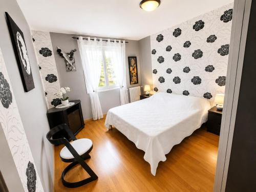 a bedroom with a bed and a chair in it at Charmant et sans chichis in Montlibert