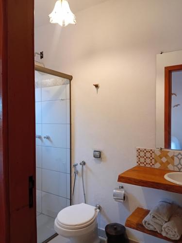a bathroom with a toilet and a shower at Chalé da Estação in Carrancas