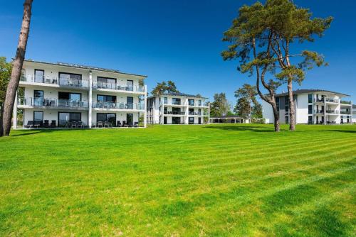 a large grassy field in front of a building at Appartement Haffperle-Oase am Haff in Garz
