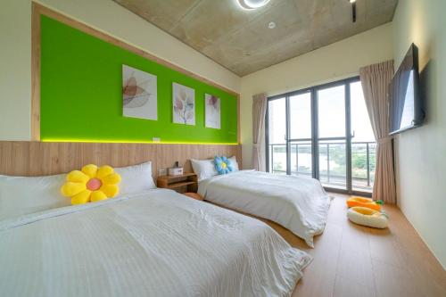 a bedroom with two beds and a green wall at 仰森水畔 in Jiaoxi